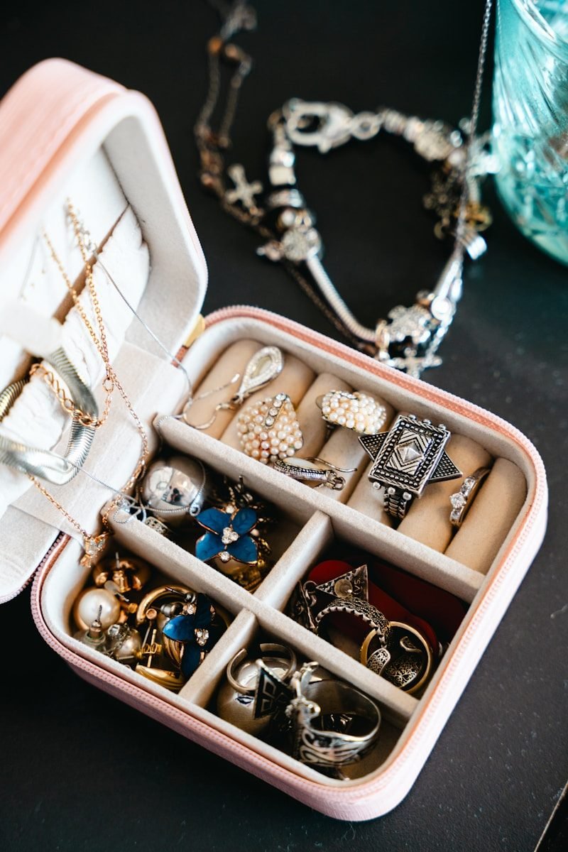A pink jewelry box filled with necklaces and rings.